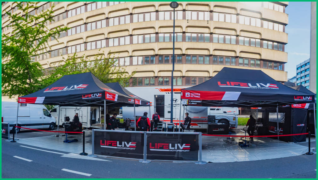 Zwart-rode LIFELIVE branded vouwtenten opgesteld voor evenement in stadscentrum bij stedelijk gebouw