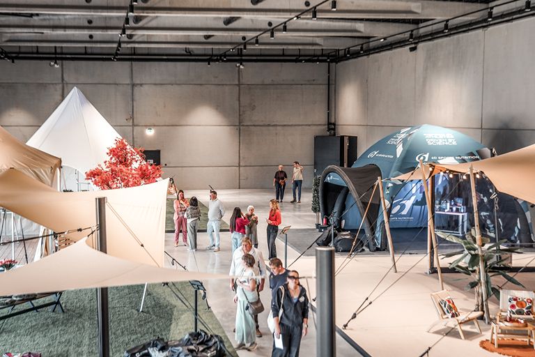 Bezoekers ontdekken stretchtenten en schaduwdoeken in de showroom van Above & Beyond